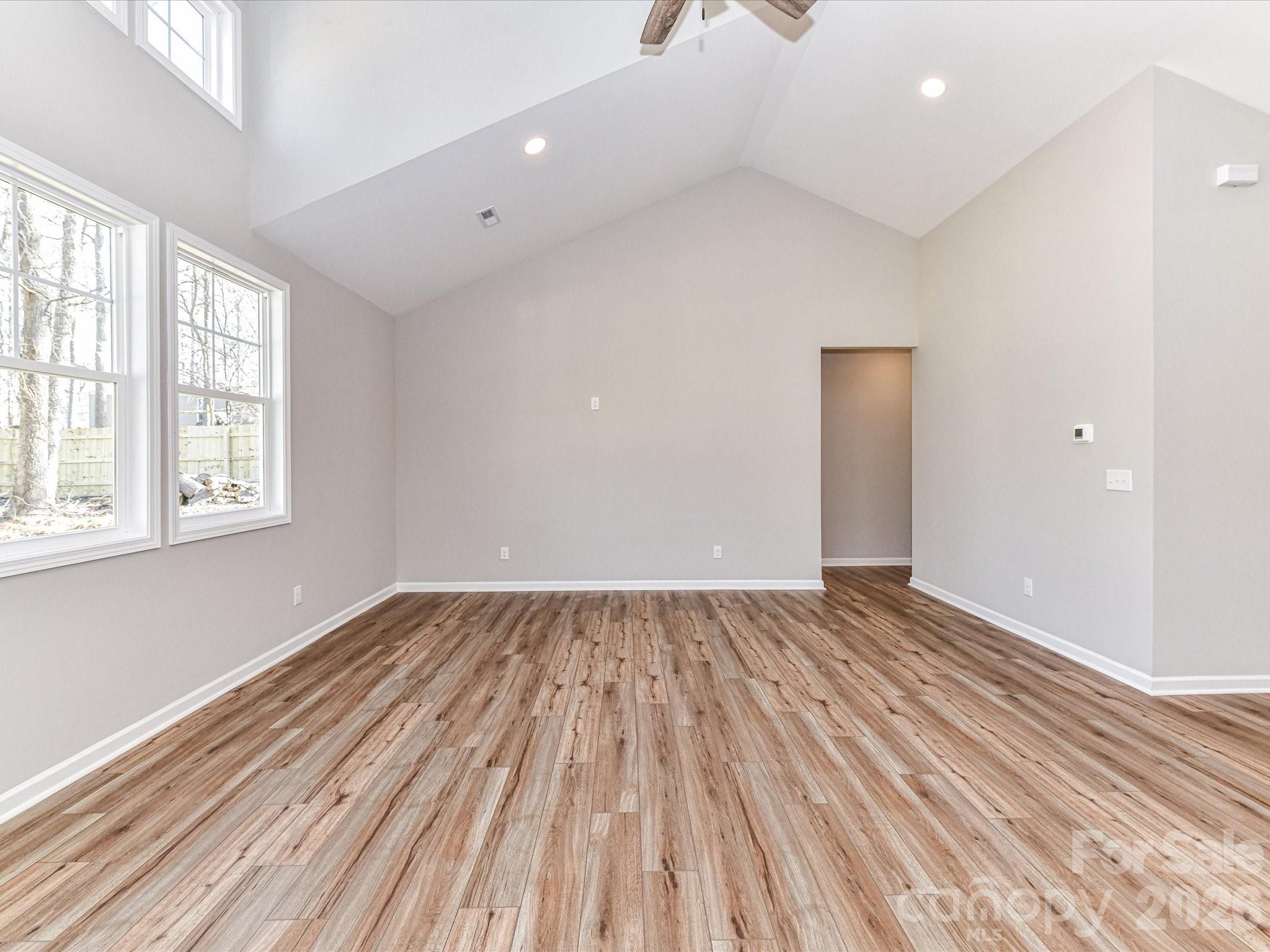104 Poplar Street Clover, SC 29710 - Photo 6 of 33 an empty room with wooden floor and windows