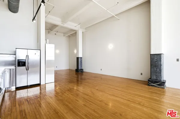 a view of a kitchen with a sink and an empty room