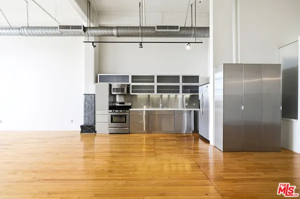 a view of a kitchen with stainless steel appliances a refrigerator and cabinets