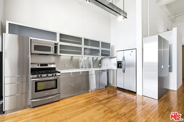 a kitchen with a refrigerator and a stove top oven