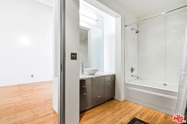 a bathroom with a tub sink and mirror