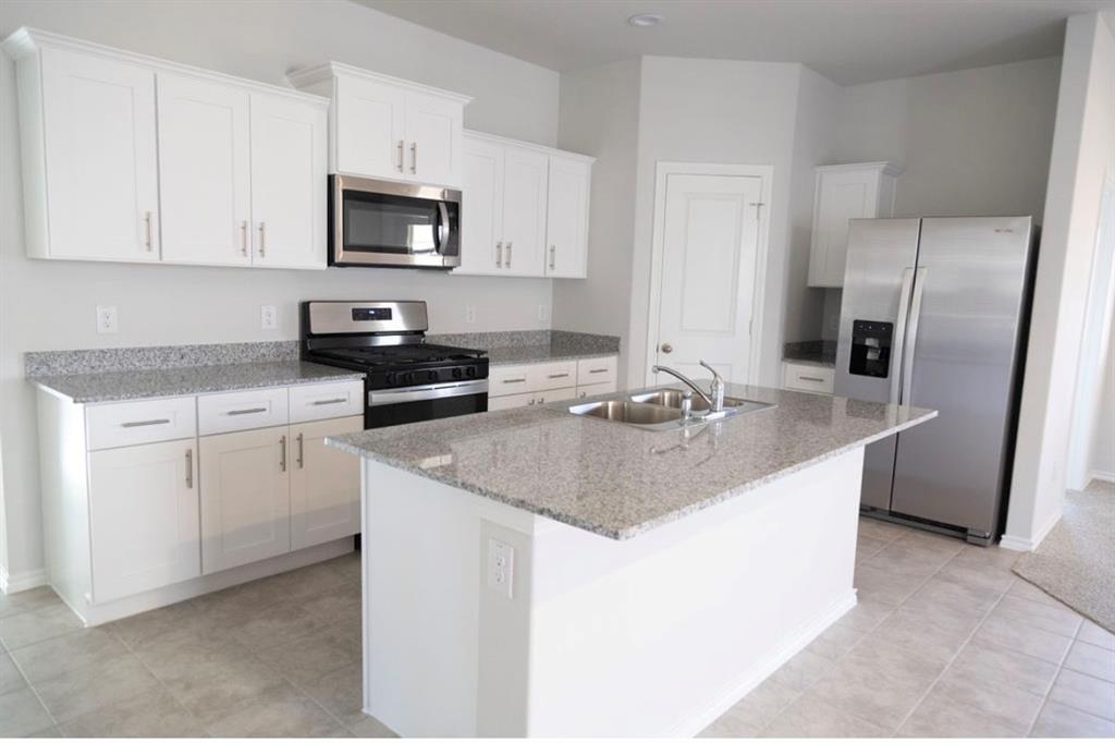 537 Derby Lane Springtown, TX 76082 - Photo 1 of 1 a kitchen with appliances a sink a stove a microwave a counter top space and cabinets