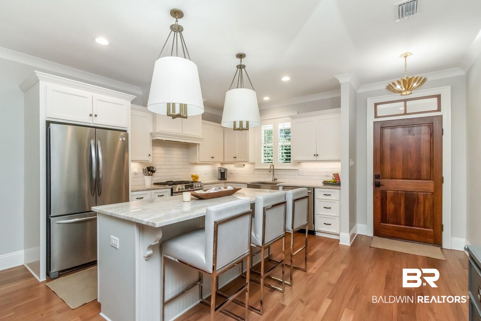 4404 Stein Street Mobile, AL 36608 - Photo 11 of 50 Kitchen with appliances with stainless steel finishes, a breakfast bar, white cabinets, crown molding, and light wood-type flooring