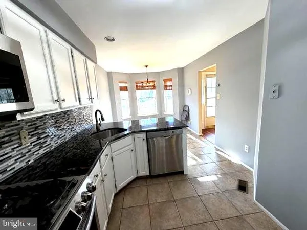 a kitchen with granite countertop a sink and a stove