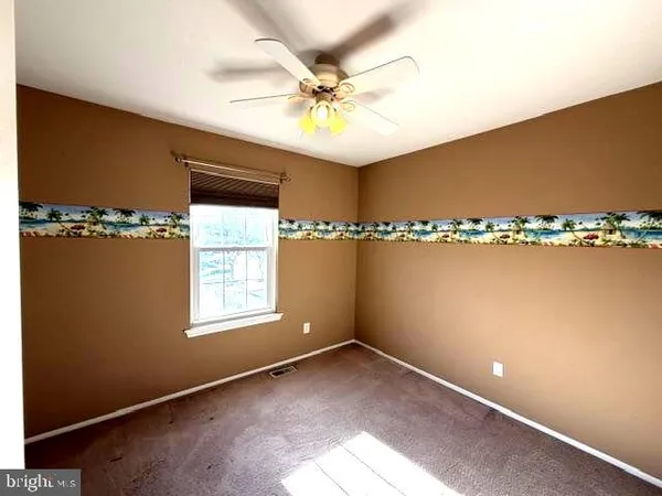 a view of a room with window and a ceiling fan