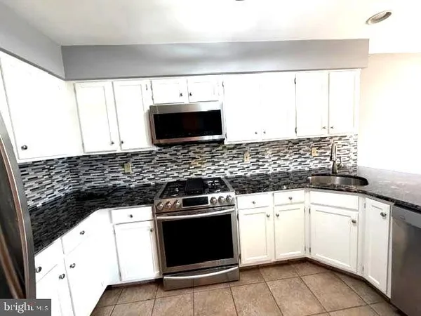 a kitchen with granite countertop a sink and a stove