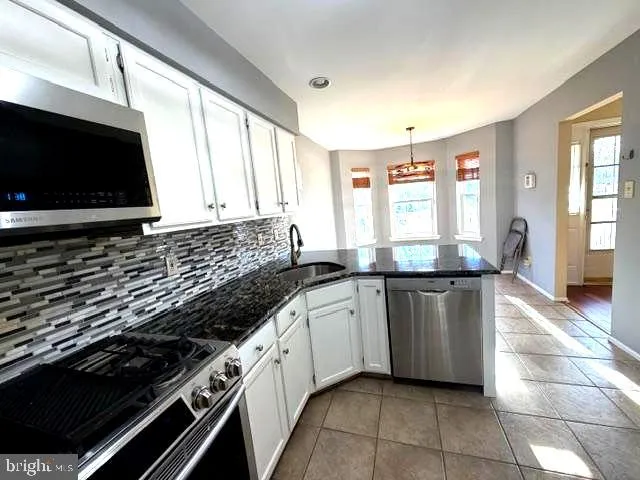 a kitchen with stainless steel appliances granite countertop a stove and a microwave