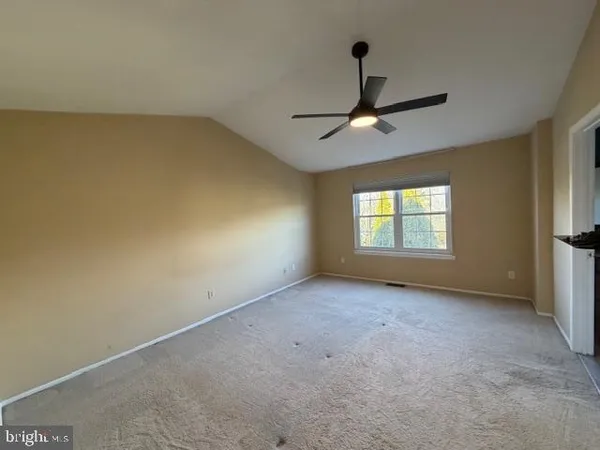 an empty room with a window and a ceiling fan