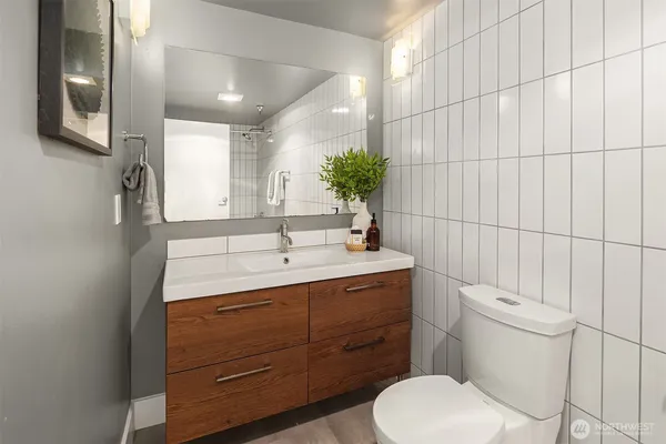 a bathroom with a toilet a sink and mirror