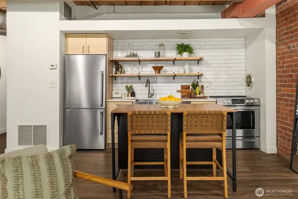 a kitchen with stainless steel appliances a refrigerator and a stove top oven