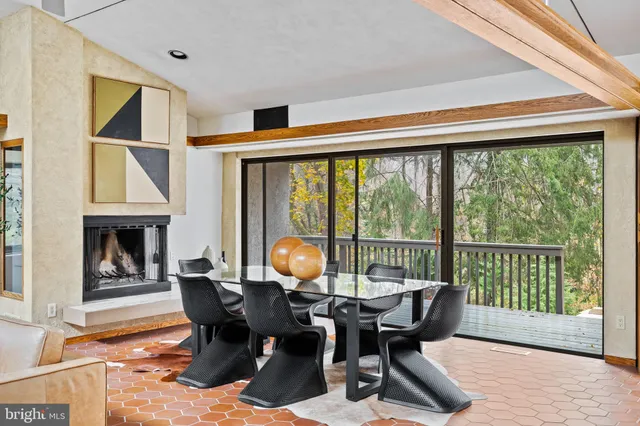 a living room with furniture a fireplace and a large window