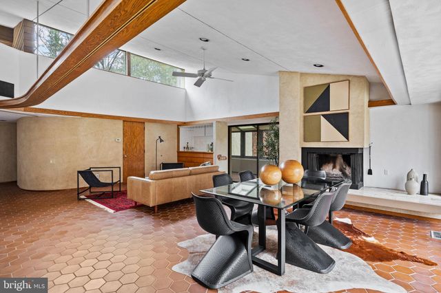 a living room with fireplace furniture and a large window