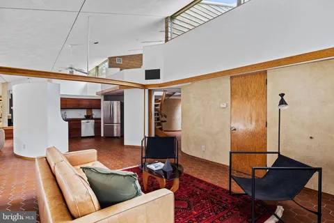 a living room with furniture fireplace and a large window