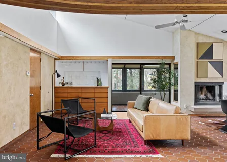 a living room with furniture a fireplace and a floor to ceiling window