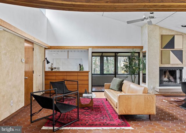 a living room with furniture a fireplace and a floor to ceiling window