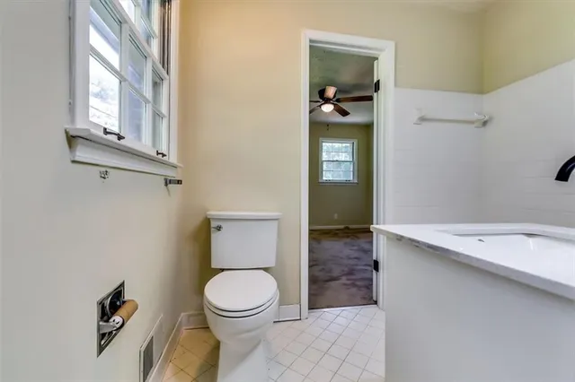 a bathroom with a toilet a sink and mirror