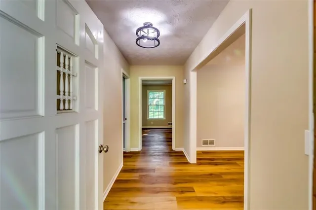 a view of empty room with wooden floor