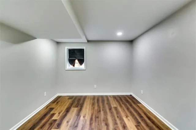 a kitchen with granite countertop a stove top oven a sink dishwasher and a refrigerator with wooden floor