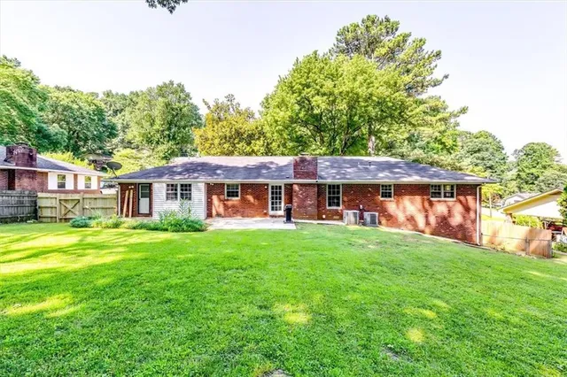 a view of a big yard with large trees and plants
