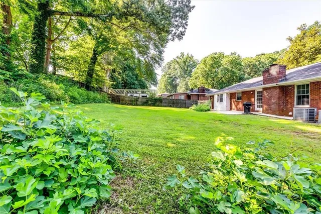 a view of backyard with potted plants and wooden fence