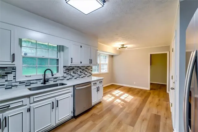 a kitchen with stainless steel appliances granite countertop a sink and a stove
