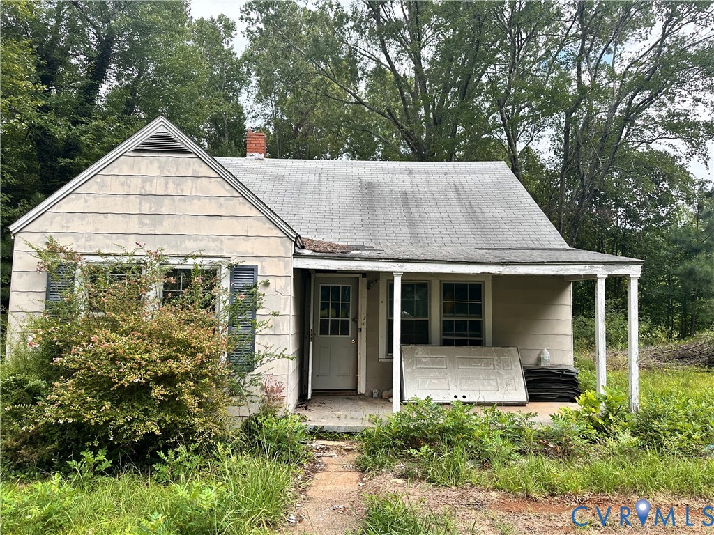 a view of a white house with large windows and a small yard