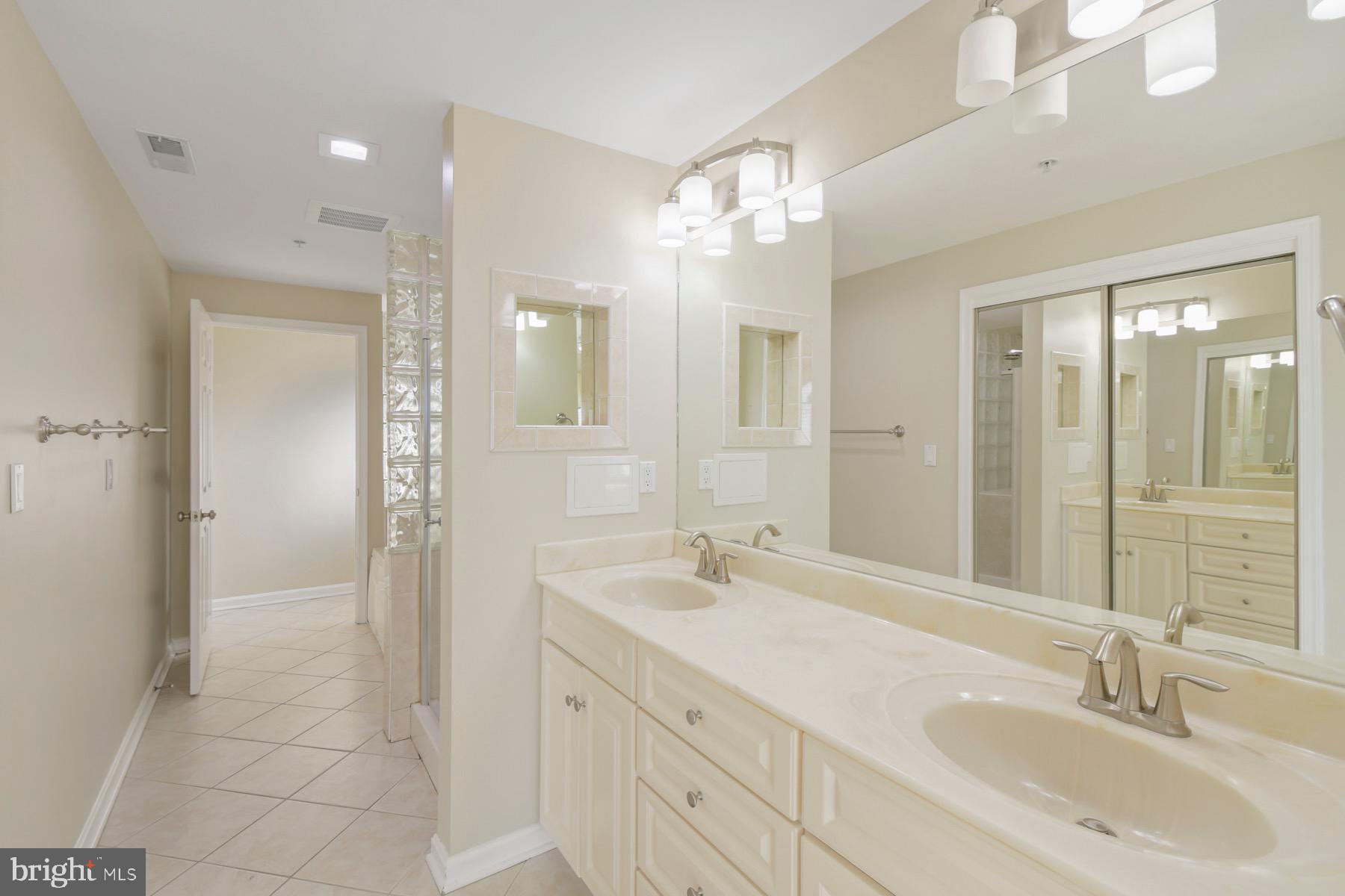 310 2nd Street, Unit 101 Ocean City, MD 21842 - Photo 16 of 37 a bathroom with double vanity sinks and a mirror
