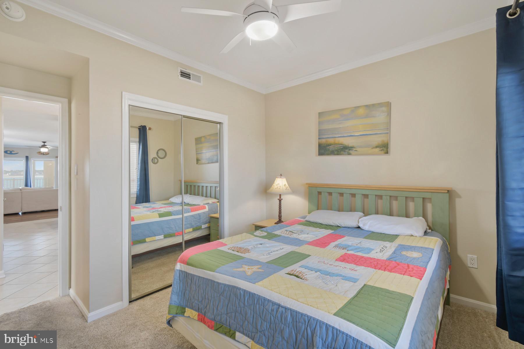 310 2nd Street, Unit 101 Ocean City, MD 21842 - Photo 20 of 37 a bedroom with a bed and a chandelier