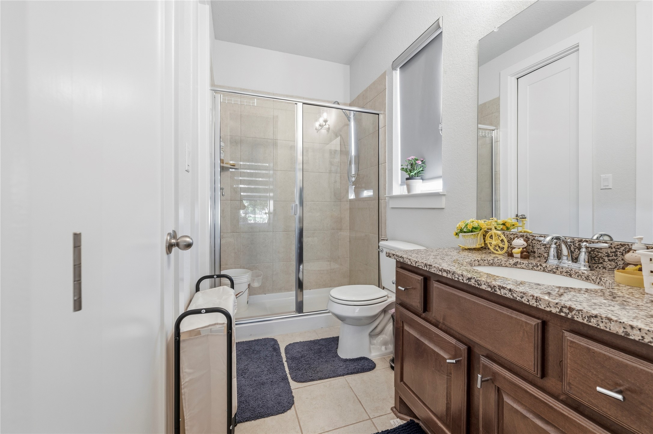 105 Autumn Oak Way Georgetown, TX 78628 - Photo 6 of 40 Bathroom featuring a glass-enclosed shower, a vanity with a granite countertop, a single basin sink, and wood-finish cabinetry
