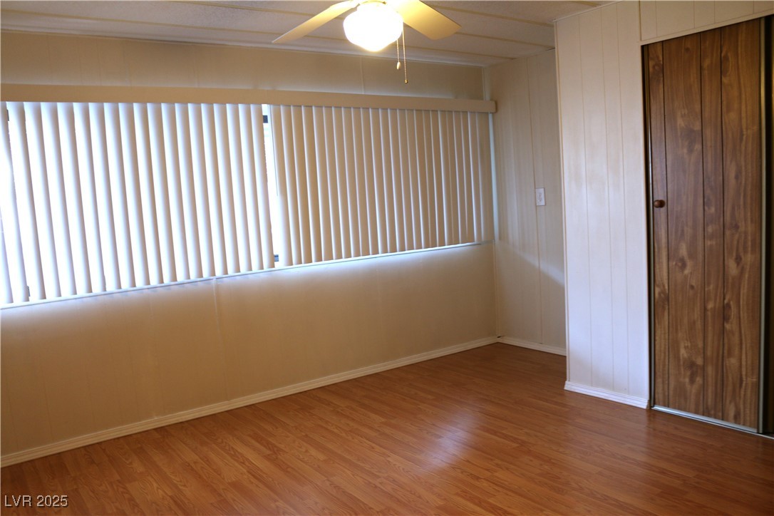 4633 Royal Ridge Boulevard Las Vegas, NV 89103 - Photo 6 of 13 Unfurnished room with a ceiling fan, baseboards, and wood finished floors