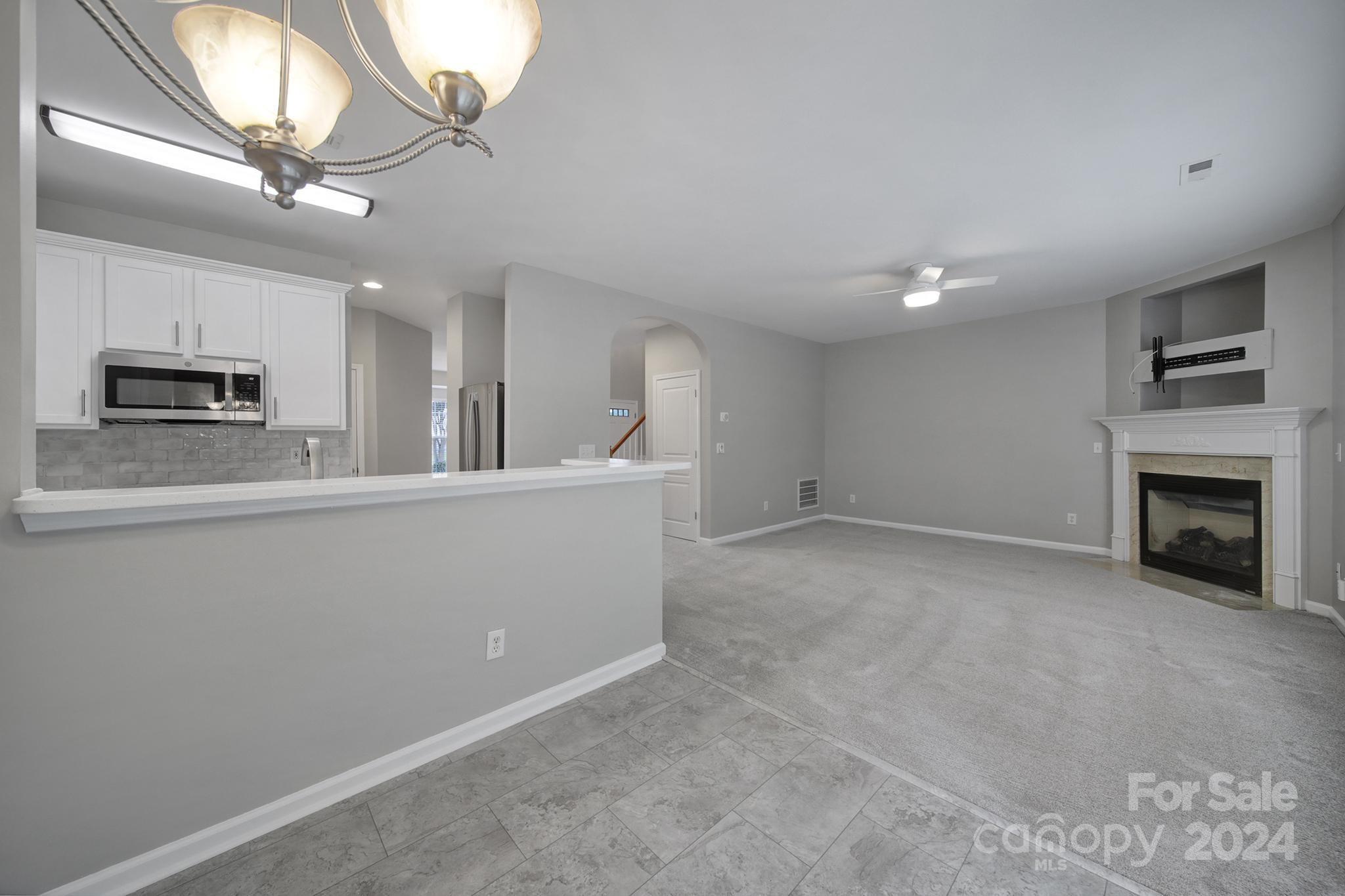 3305 Adair Marble Street Fort Mill, SC 29708 - Photo 16 of 38 a view of a kitchen with a sink and a fireplace