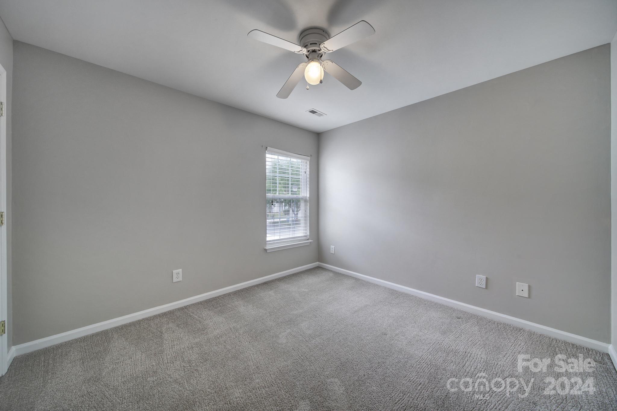 3305 Adair Marble Street Fort Mill, SC 29708 - Photo 27 of 38 an empty room with a chandelier fan and windows