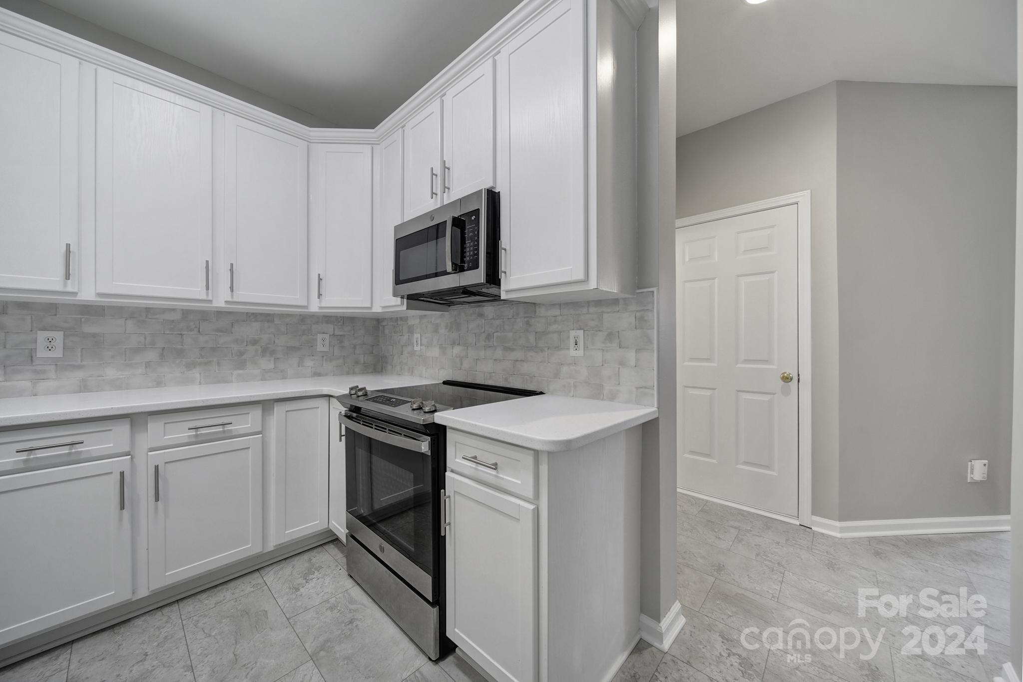 3305 Adair Marble Street Fort Mill, SC 29708 - Photo 9 of 38 a kitchen with white cabinets and white appliances