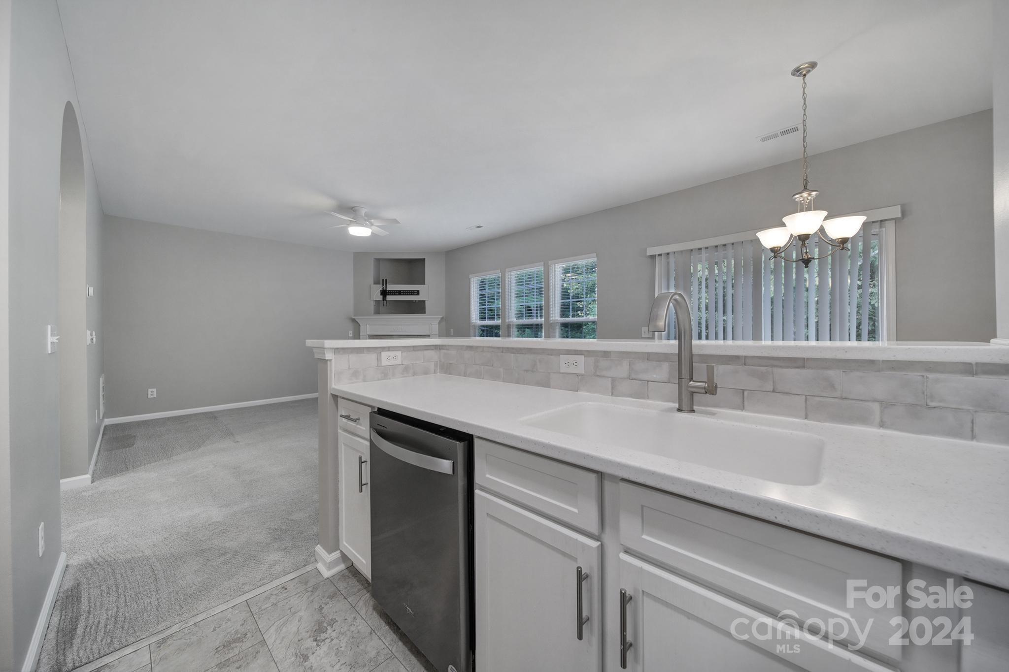 3305 Adair Marble Street Fort Mill, SC 29708 - Photo 10 of 38 a kitchen with kitchen island a sink stainless steel appliances and a chandelier