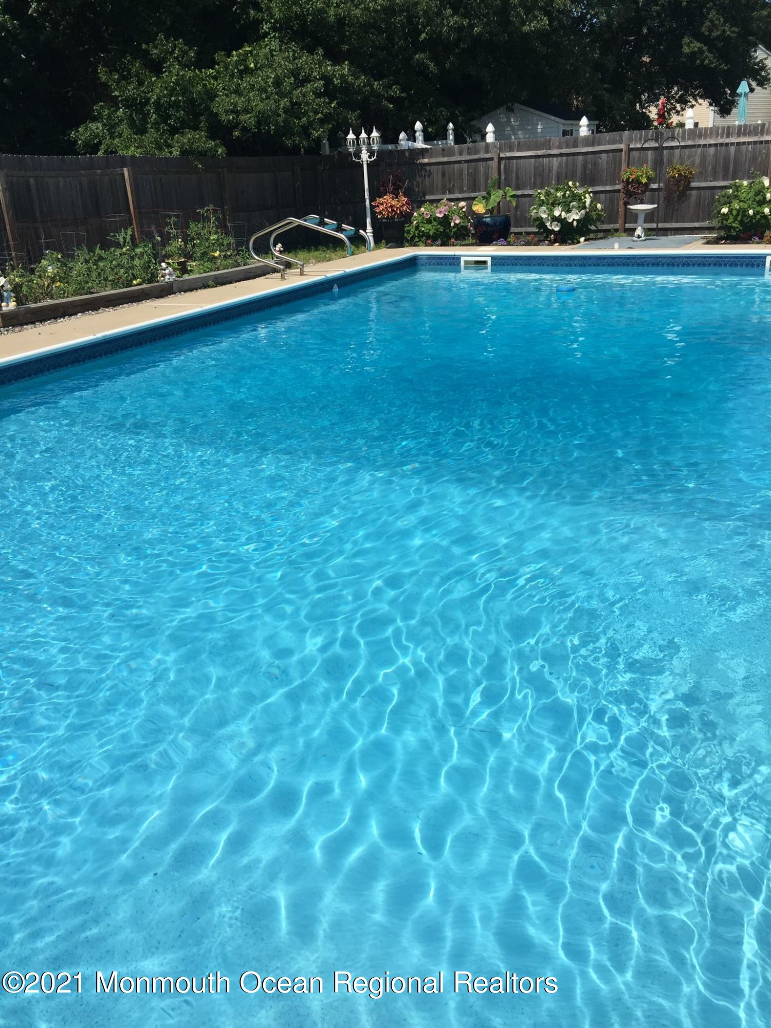 63 Hedgewood Road Howell, NJ 07731 - Photo 23 of 25 a view of a swimming pool with lawn chairs and plants