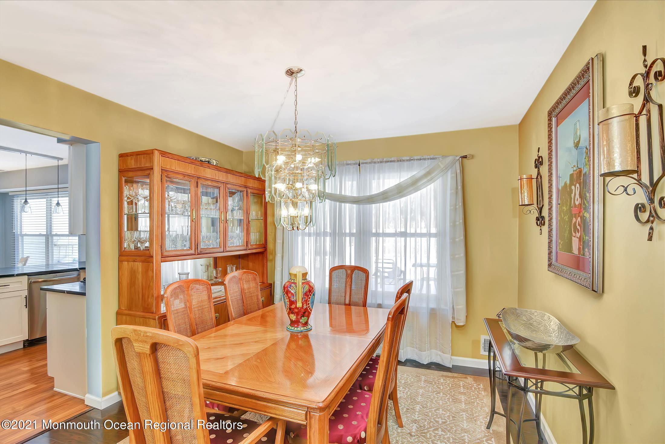 63 Hedgewood Road Howell, NJ 07731 - Photo 6 of 25 a view of a dining room with furniture a chandelier and large windows