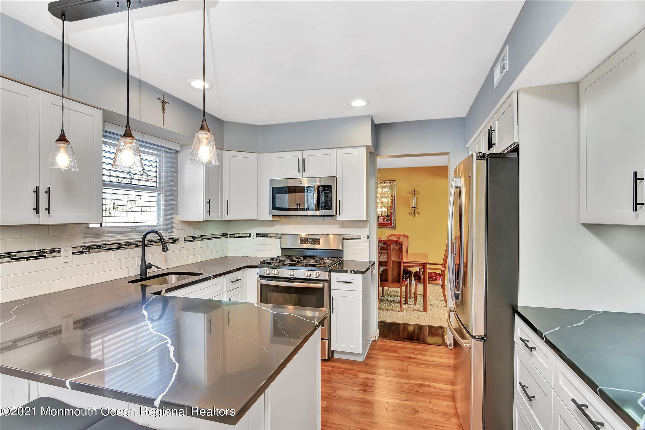 63 Hedgewood Road Howell, NJ 07731 - Photo 7 of 25 a kitchen with stainless steel appliances granite countertop a sink a stove top oven a counter space and cabinets