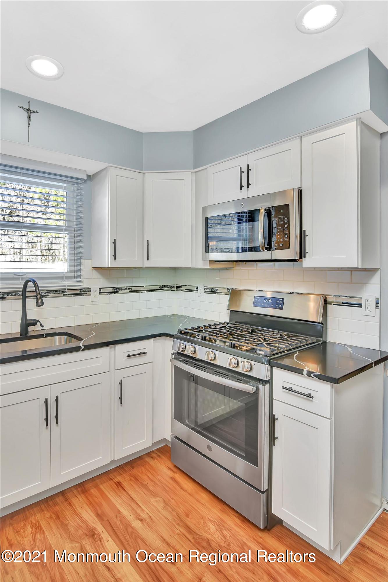 63 Hedgewood Road Howell, NJ 07731 - Photo 9 of 25 a kitchen with granite countertop a stove a sink and a microwave
