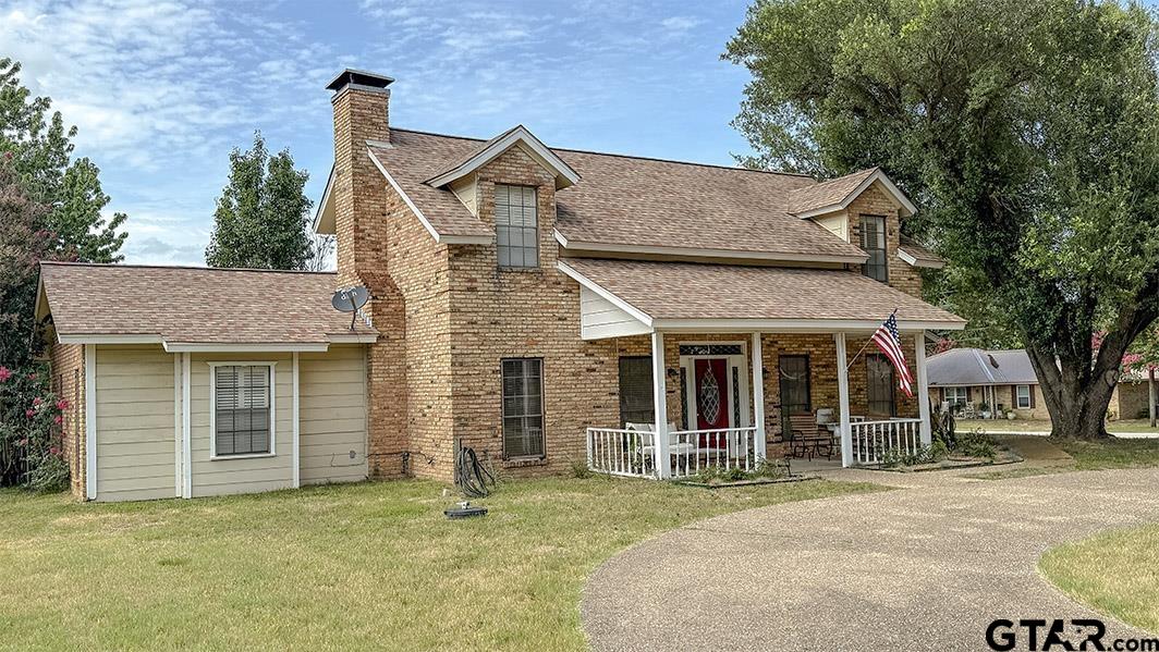 a front view of a house with a garden and tree