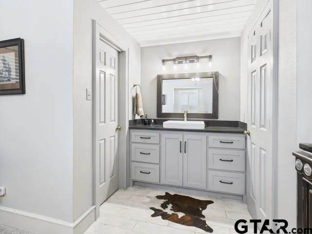 a spacious bathroom with a granite countertop sink and a mirror