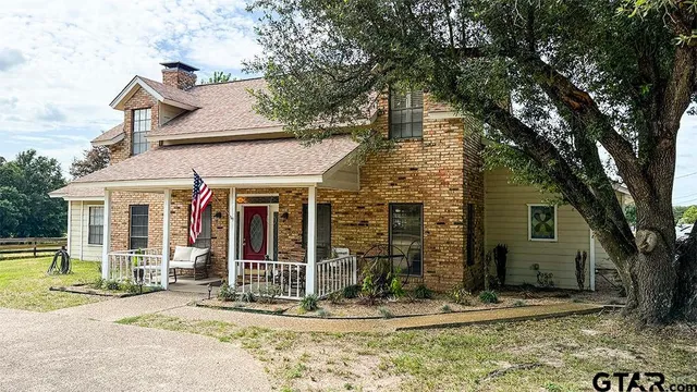 a view of a chair and fire pit in the backyard of a house