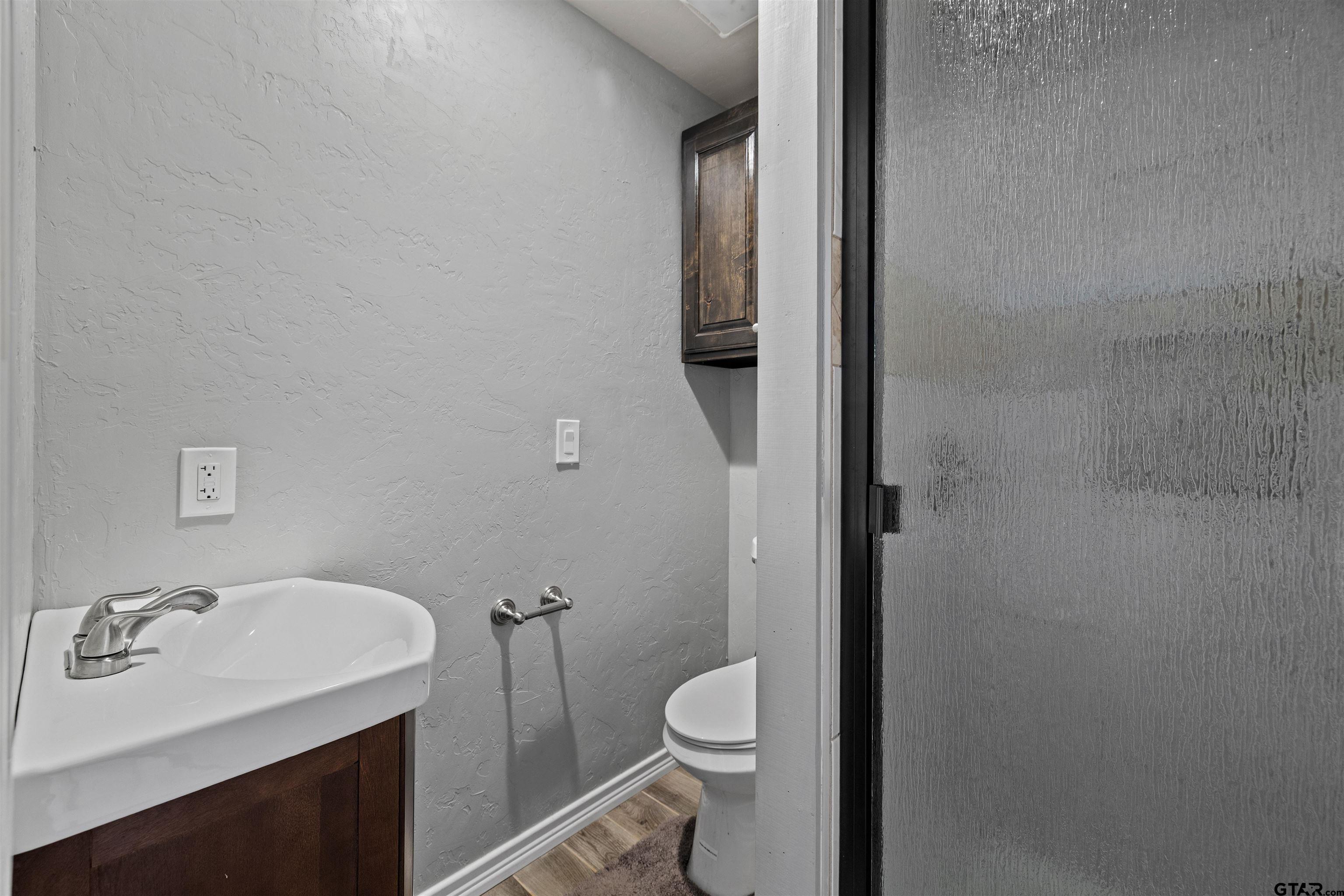 5796 Highway 271 Pittsburg, TX 75686 - Photo 25 of 43 a bathroom with a sink and mirror with toilet