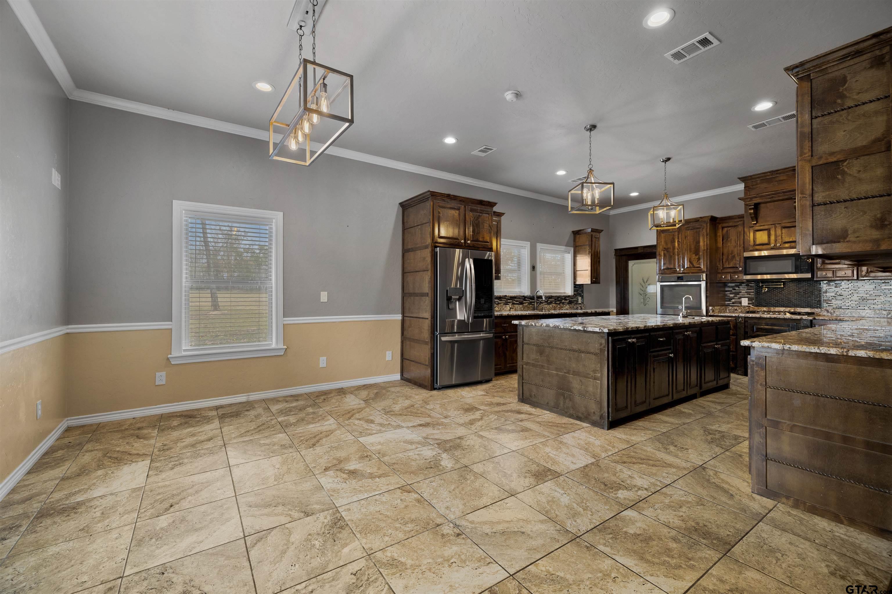 5796 Highway 271 Pittsburg, TX 75686 - Photo 9 of 43 a kitchen with stainless steel appliances kitchen island granite countertop a sink and cabinets
