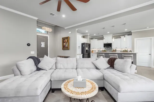 a living room with furniture and kitchen view