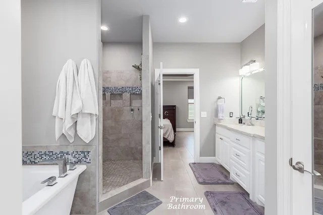 a bathroom with a double vanity sink a mirror a bathtub and shower