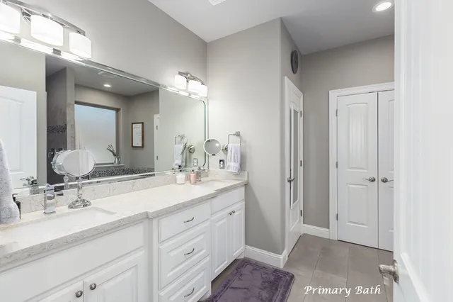 a spacious bathroom with a double vanity sink mirror and double