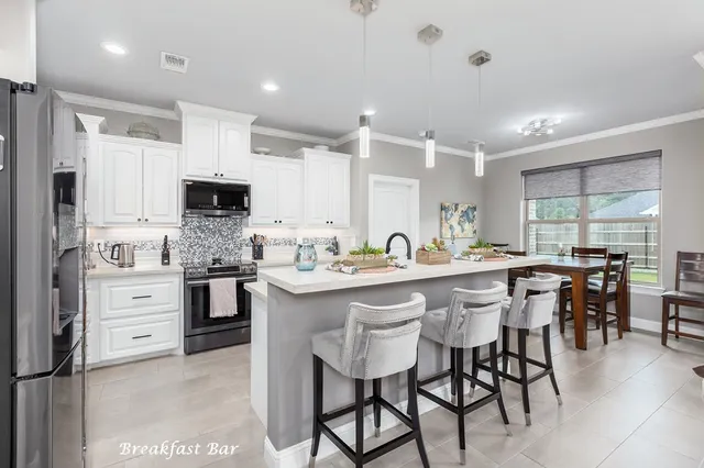 a kitchen with kitchen island granite countertop a sink counter top space appliances and cabinets