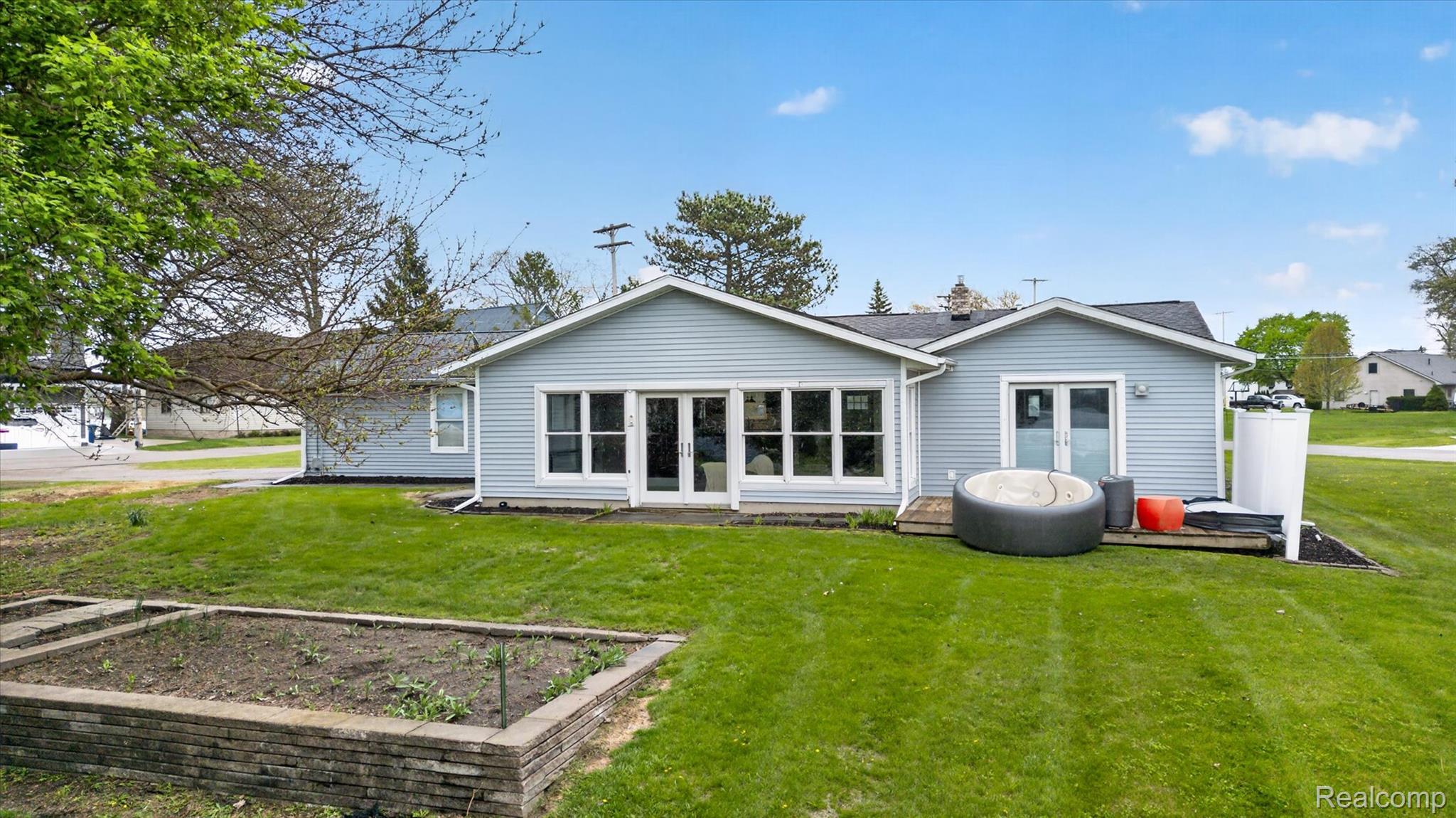 2264 Crane Road Fenton, MI 48430 - Photo 4 of 55 Back of house featuring french doors, a garden, and a lawn