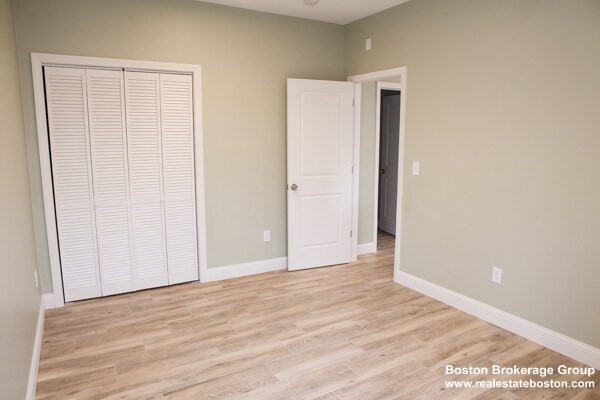 10 Roxbury Street, Unit 10 Boston, MA 02119 - Photo 2 of 8 a view of an empty room with wooden floor