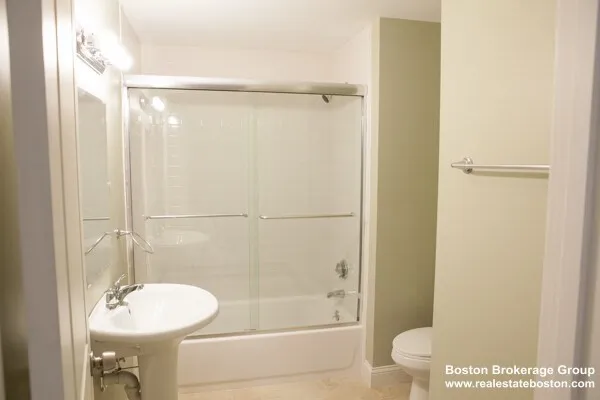 a bathroom with a shower a toilet and a sink